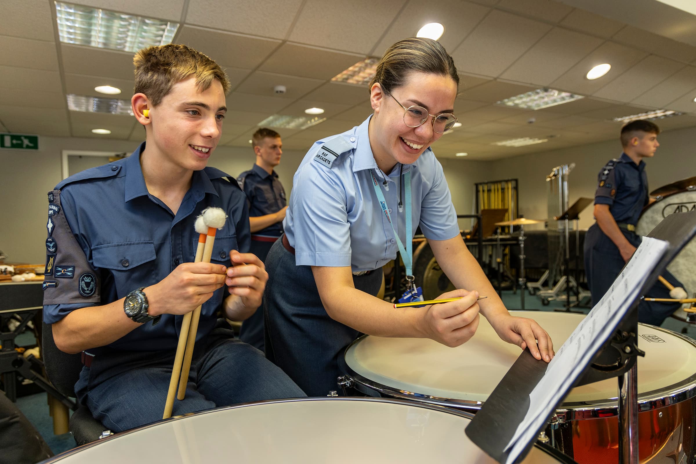 Staff member teaching music to a cadet